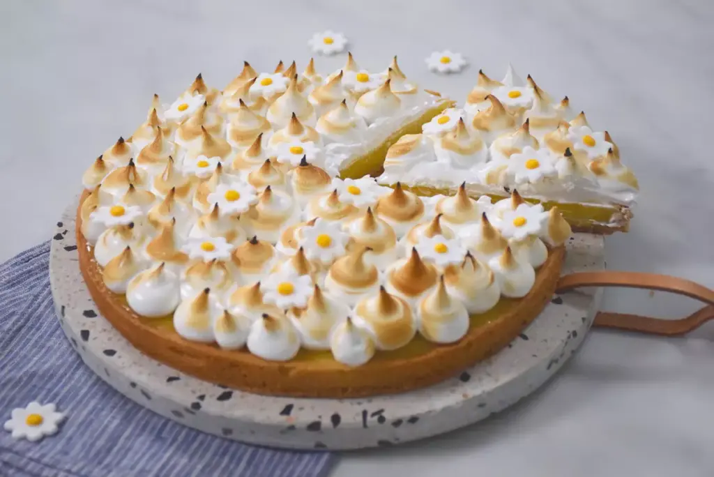 Une tarte aux citrons meringuée sur une assiette.